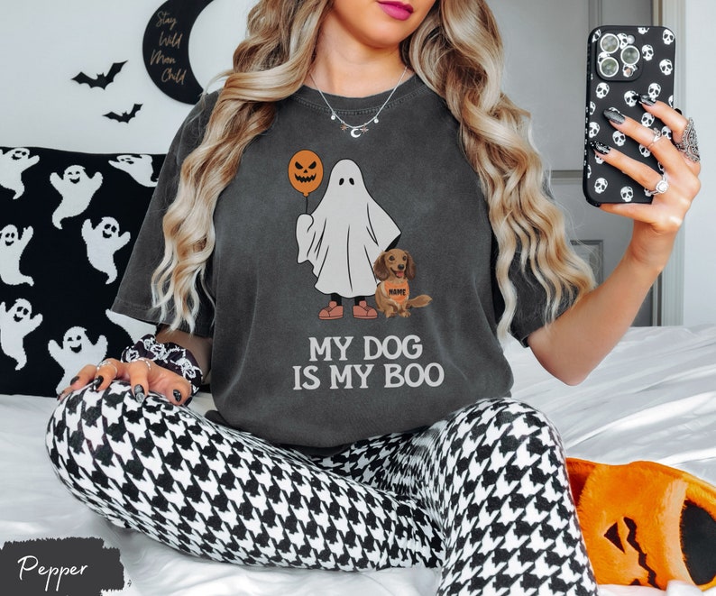 a woman sitting on a bed holding a cell phone