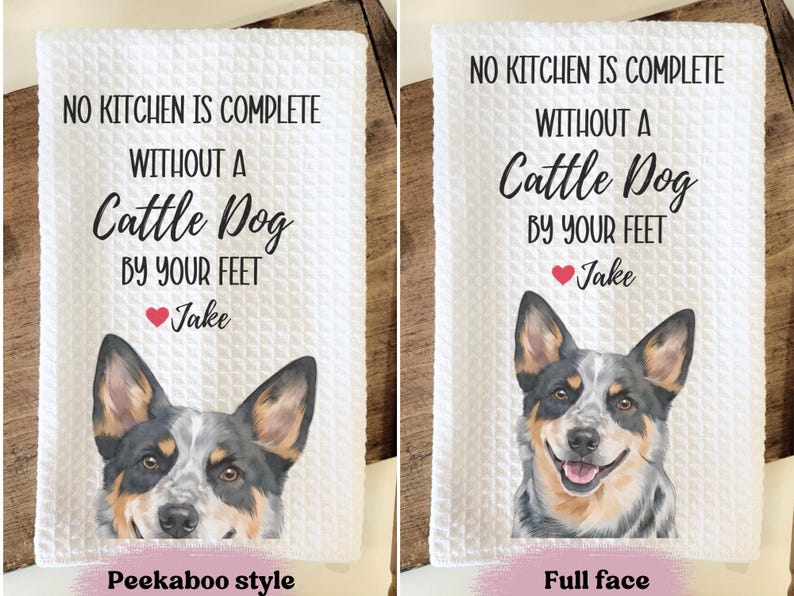 two towels with a humorous message about a dog. The towels feature a cute image of a dog's face and the text "No kitchen is complete without a Cattle Dog by your feet" along with a heart symbol and the name "Jake". The towels are labeled as "Peekaboo style" and "Full face" to indicate the style of the towel.