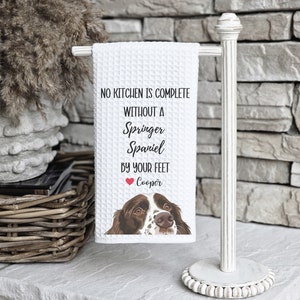 May include: White kitchen towel with a brown and white Springer Spaniel dog illustration and the text "No kitchen is complete without a Springer Spaniel by your feet" with a red heart and the name "Cooper" underneath.