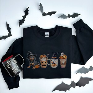 a black shirt with three cups of coffee and bats