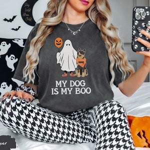 a woman sitting on a bed holding a cell phone