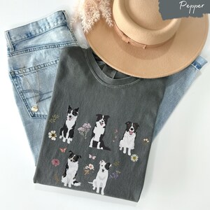 May include: A dark gray t-shirt with a graphic of five border collies surrounded by flowers and butterflies. The text "Pepper" is in the upper right corner of the image.
