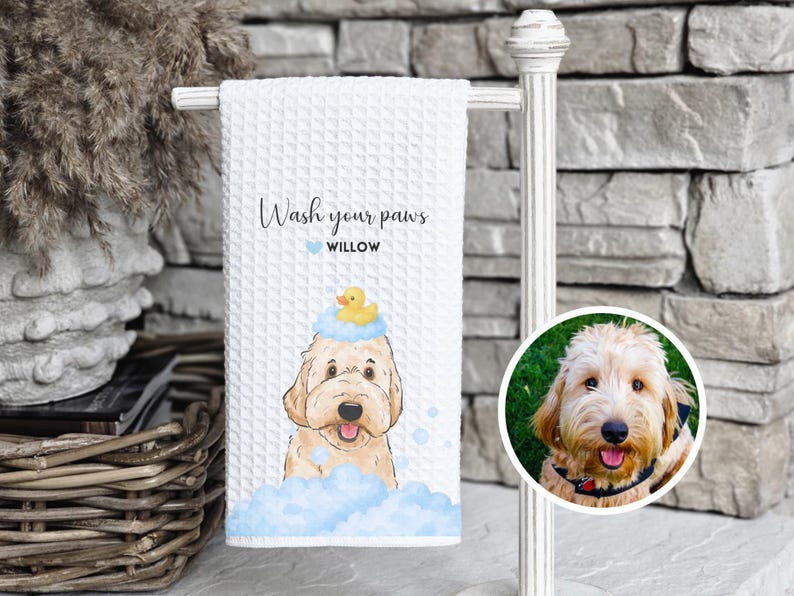 May include: White waffle-weave towel with a watercolor illustration of a dog wearing a rubber ducky on its head, surrounded by blue bubbles. Text reads "Wash your paws" and "Willow". A circular photo of a dog is on the right.