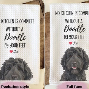 two towels with a humorous message about a dog. The towels feature a cartoon image of a dog's face and the text "No kitchen is complete without a Doodle by your feet Joe" along with the text "Peekaboo style" and "Full face" indicating the style of the towel.