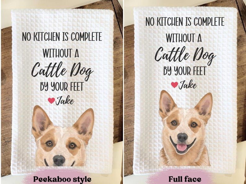 two towels with a humorous message about having a cattle dog by one's feet. The towels feature a cartoon image of a dog's face and the text "NO KITCHEN IS COMPLETE WITHOUT A Cattle Dog BY YOUR FEET Jake" along with the text "Peekaboo style" and "Full face" indicating the style of the towel.