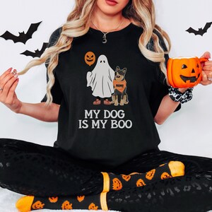 a woman in a black shirt is holding a pumpkin