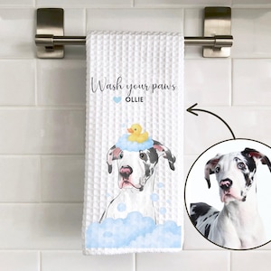 May include: White waffle-weave hand towel with a watercolor illustration of a Great Dane dog wearing a yellow rubber ducky on its head. The towel reads "Wash your paws" and the dog's name, Ollie.