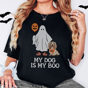 a woman wearing a black shirt with a dog and a ghost on it
