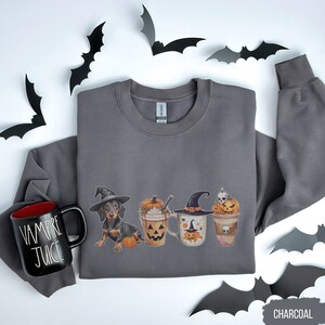 a gray shirt with a cup of coffee and some bats