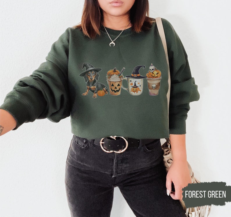 a woman wearing a green sweatshirt with halloween pictures on it