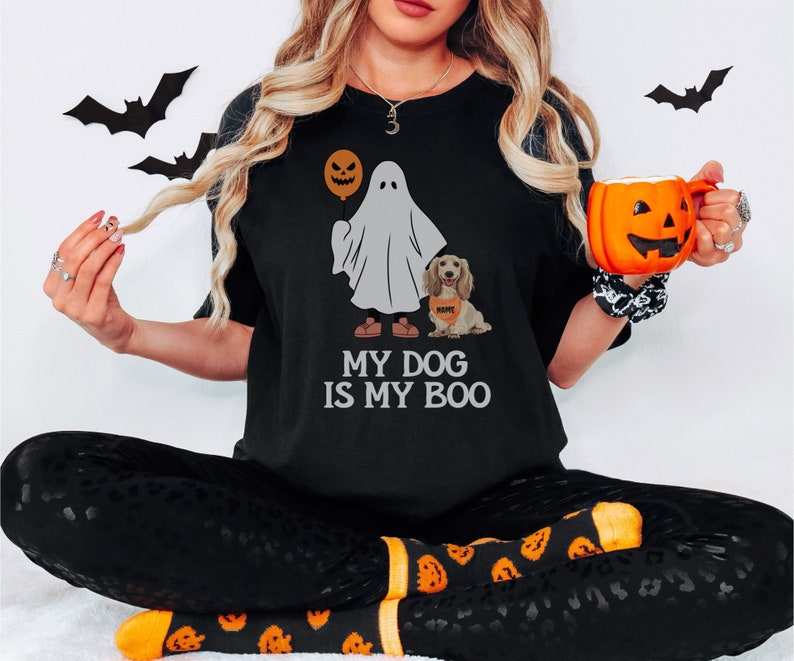 a woman in a black shirt is holding a pumpkin