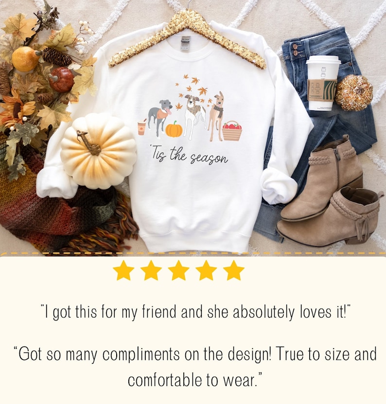 Puede incluir: Sudadera blanca con un gr&aacute;fico de tres perros y una calabaza. El texto "Tis the season" est&aacute; impreso debajo del gr&aacute;fico.