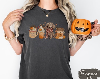 Op de afbeelding: Een donkergrijs T-shirt met een afbeelding van een teckel, een pumpkin spice latte en een herfst-thema koffiebeker. De tekst "Pumpkin Spice" staat op de koffiebeker.
