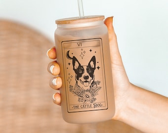 May include: A frosted glass tumbler with a bamboo lid and a straw. The tumbler features a black and white illustration of a dog with the text "VI - THE CATTLE DOG -" printed on the side.