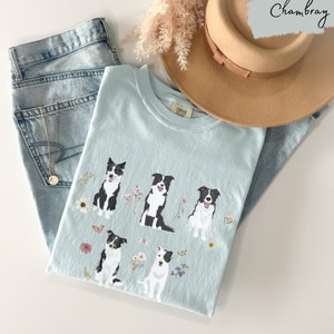 May include: A light blue t-shirt with a graphic of five black and white border collies surrounded by flowers and butterflies. The text "CONTEST READY" is printed on the shirt.