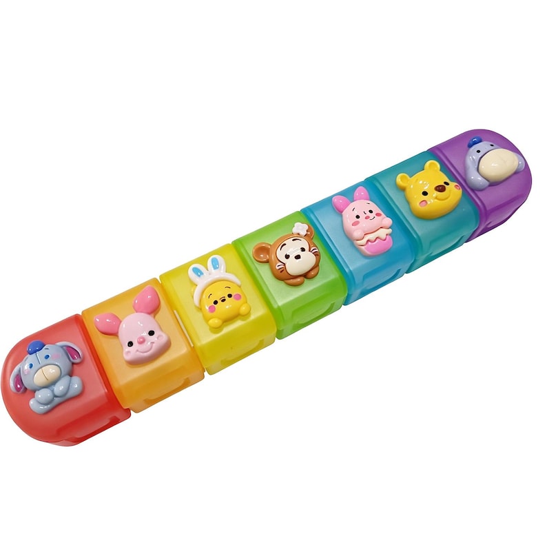 May include: A colorful toy featuring Winnie the Pooh characters. The toy is composed of connected blocks in various colors, each with a character's face. Characters include Eeyore, Piglet, Rabbit, Tigger, Pooh, and a pink character. The toy is designed for children.