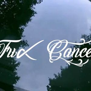 May include: White vinyl decal with the words "Truck Cancer" written in a cursive font.