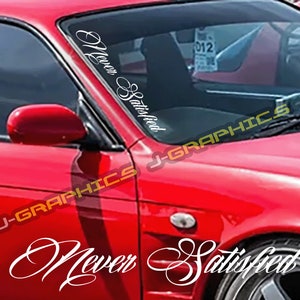 May include: A red car with a white vinyl decal on the windshield that says "Never Satisfied".