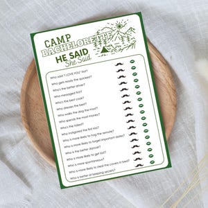 May include: A green and white printable game card with the text "Camp Bachelorette He Said She Said" and a list of questions to ask guests at a bachelorette party.