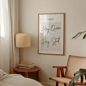 May include: A framed print with the text "Hey Queen" and "Hey Stud" in a handwritten font. The print is in a wooden frame and hangs on a light-colored wall. The print is part of a bedroom decor.