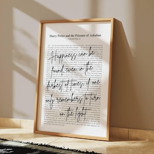 May include: A framed print featuring text from "Harry Potter and the Prisoner of Azkaban." The quote, "Happiness can be found, even in the darkest of times, if one only remembers to turn on the light," is written in a stylish font.