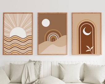 May include: Three abstract art prints with a desert theme. The first print features a sun with rays and wavy lines. The second print features a crescent moon and a rainbow arch. The third print features a crescent moon and a rainbow arch with a small plant.