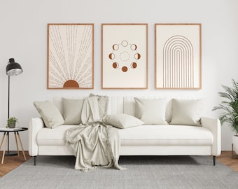 May include: Three framed prints with minimalist geometric designs in shades of brown and white. The prints are hung on a white wall above a white sofa with beige throw pillows and a beige throw blanket.