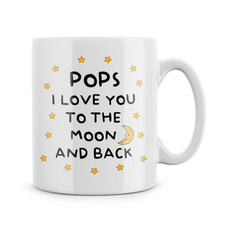 May include: White ceramic mug with a black and yellow design. The mug says "Pops I love you to the moon and back" with a yellow crescent moon and stars.