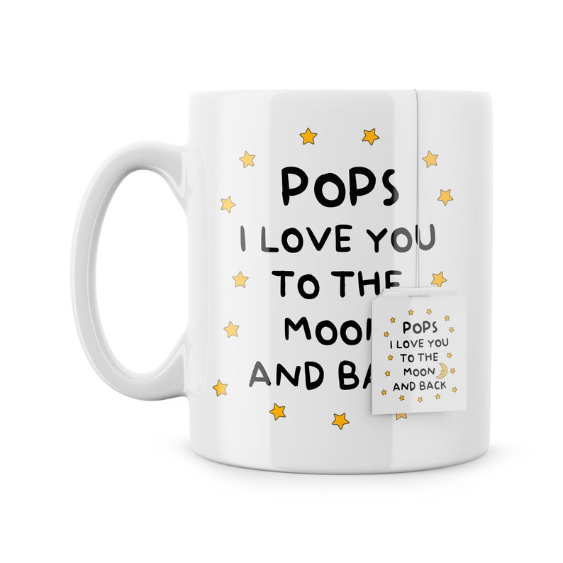 May include: White ceramic mug with a black and white design that says "Pops I Love You To The Moon And Back" with yellow stars and a tea bag that says "Pops I Love You To The Moon And Back".