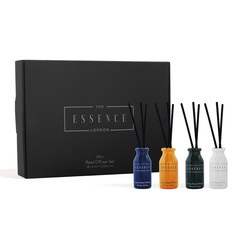 May include: A mini reed diffuser set by The Essence London. The set includes a black box and four small, colorful bottles: blue, orange, dark green, and white. Each bottle contains black reeds for fragrance diffusion. The bottles are 15 ml / 1.0 fl oz each.