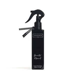 May include: A black rectangular bottle of "Oriental Moment" luxury home spray with a black trigger sprayer. The bottle has a white label with the text "THE ESSENCE LONDON" and a tag with the same text. The bottle contains 300 ml / 10.14 fl.oz.