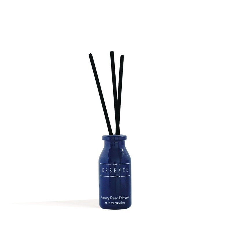 May include: A navy blue reed diffuser with black reeds. The bottle has a white label with the text "THE ESSENCE LONDON" and "Luxury Reed Diffuser e 15 ml / 0.5 fl.oz."
