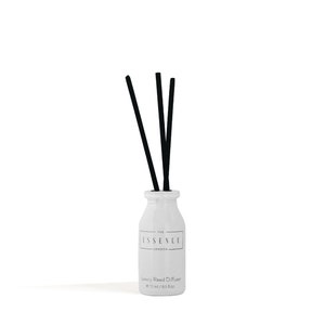 May include: A white ceramic reed diffuser with three black reeds. The bottle has a label that reads "THE ESSENCE LONDON" and "Luxury Reed Diffuser e 15 ml / 0.5 fl oz."