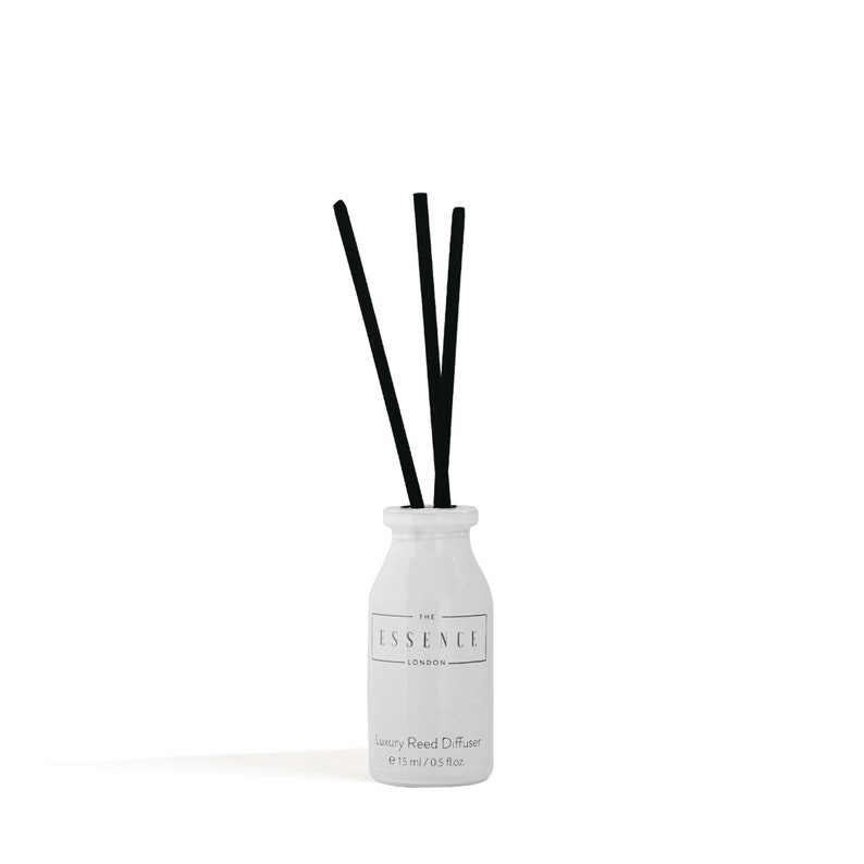 May include: A white ceramic reed diffuser with three black reeds. The bottle has a label that reads "THE ESSENCE LONDON" and "Luxury Reed Diffuser e 15 ml / 0.5 fl oz."