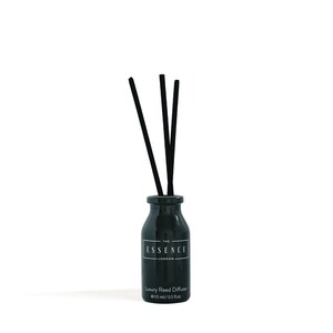 May include: A black glass reed diffuser with three black reeds. The bottle has a white label with the text "THE ESSENCE LONDON" and "Luxury Reed Diffuser e 15 ml / 0.5 fl.oz."