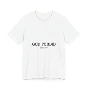 May include: White t-shirt with the text "GOD FORBID" above "I DARE YOU" in black, sans-serif font. The shirt has a crew neck and short sleeves. The garment is made of a soft, lightweight material.
