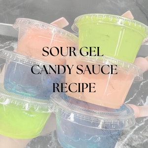 Puede incluir: Cuatro vasos de plástico transparente llenos de salsa de caramelo de gel agrio de diferentes colores. Los vasos están apilados uno encima del otro y el texto "Sour Gel Candy Sauce Recipe" está escrito en negro en los vasos. El texto "@Mainly Sweets" está escrito en negro en la parte inferior de la imagen.
