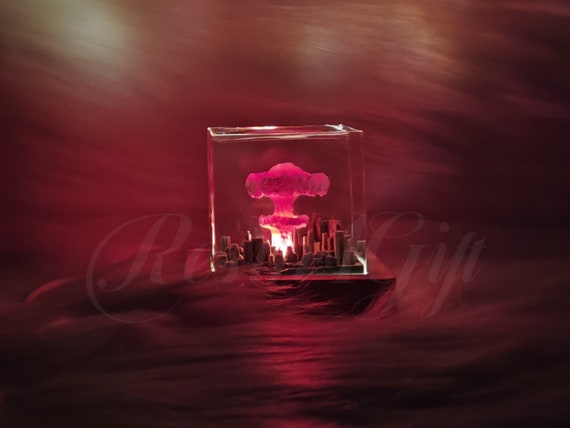 A mushroom-cloud explosion frozen in epoxy resin and lit from below — equal parts terrifying and gorgeous, the kind of lamp that makes guests stop mid-sentence.