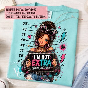 May include: A light blue t-shirt featuring a graphic illustration of a person with brown hair wearing leopard print sunglasses and holding a sign that reads I'M NOT EXTRA You're just basic. The design includes a height chart from 2'6" to 5'6".