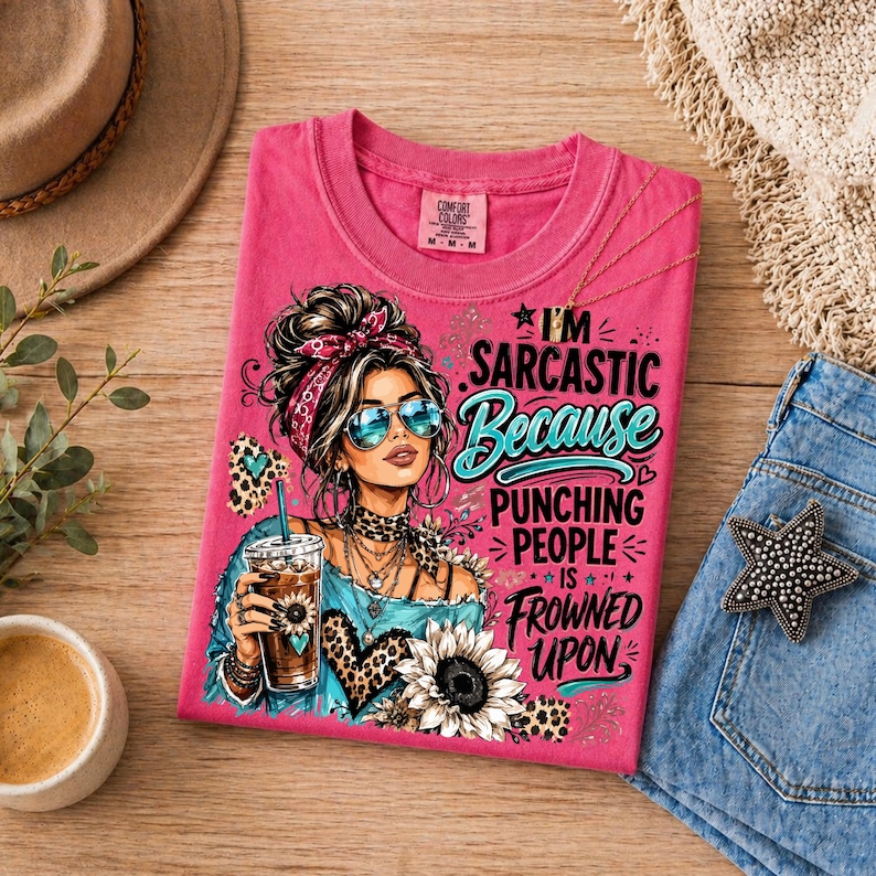 Pode incluir: Uma t-shirt rosa com o gr&aacute;fico de uma pessoa com fita na cabe&ccedil;a, &oacute;culos de sol e uma bebida. O texto diz: I'M SARCASTIC Because PUNCHING PEOPLE IS FROWNED UPON. O design inclui detalhes com estampa de leopardo e uma ilustra&ccedil;&atilde;o de girassol.