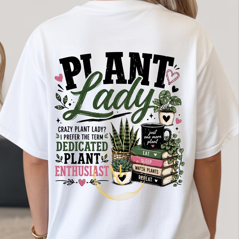 May include: A white t-shirt featuring a graphic on the back with the text "PLANT LADY" and "CRAZY PLANT LADY? I PREFER THE TERM DEDICATED PLANT ENTHUSIAST". The design includes illustrations of potted plants, a stack of books, and small hearts.