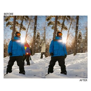 Op de afbeelding: Een persoon in een blauwe jas en een zwarte broek snowboardt een besneeuwde heuvel af. De persoon draagt een zwarte helm en een skibril. De zon schijnt fel op de achtergrond.