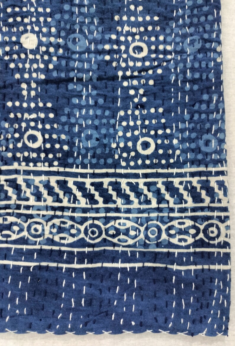 Pode incluir: Uma colcha kantha azul com um padr&atilde;o geom&eacute;trico branco. A colcha &eacute; feita de algod&atilde;o e tem um design costurado &agrave; m&atilde;o.