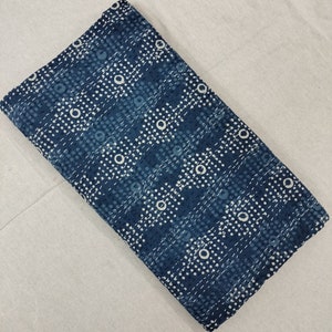 Pode incluir: Um tecido azul com um padr&atilde;o de bolinhas brancas. O tecido tem uma textura sutil e um visual ligeiramente desbotado.