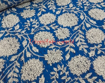 May include: Blue cotton fabric with a white floral print. The fabric has a textured surface and a subtle sheen.