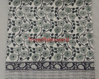 May include: White cotton fabric with a green floral print. The fabric has a black border with a white floral pattern and a black and white striped border.