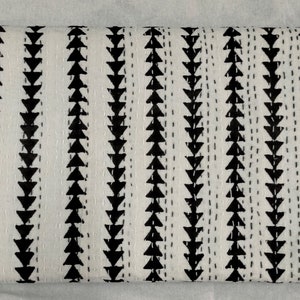 May include: White cotton throw blanket with a black and white geometric pattern of triangles. The pattern is repeated in rows across the blanket.