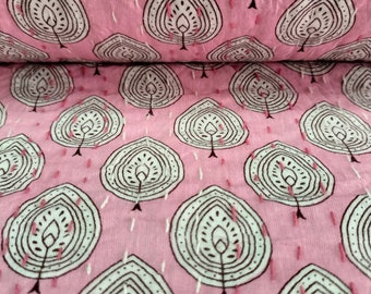 May include: Pink fabric with a repeating pattern of white and brown stylized trees. The fabric has a quilted texture.