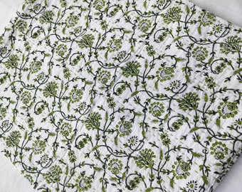 Könnte beinhalten: Weißer Stoff mit grünem Blumenmuster. Das Muster zeigt kleine grüne Blumen und Blätter auf weißem Hintergrund.
