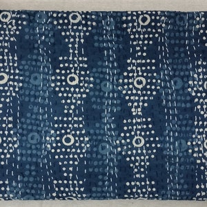 Pode incluir: Um tecido azul com um padr&atilde;o branco de pequenos pontos e c&iacute;rculos. O tecido tem uma superf&iacute;cie texturizada.